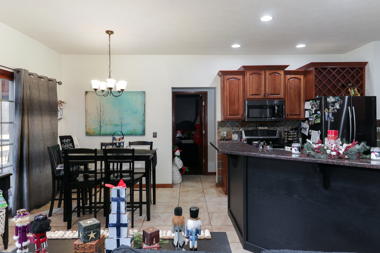 938 Kickapoo Drive Danvers, IL 61732 - Photo 10 of 49 a kitchen area with stainless steel appliances a sink dishwasher a refrigerator and a dining table with wooden floor