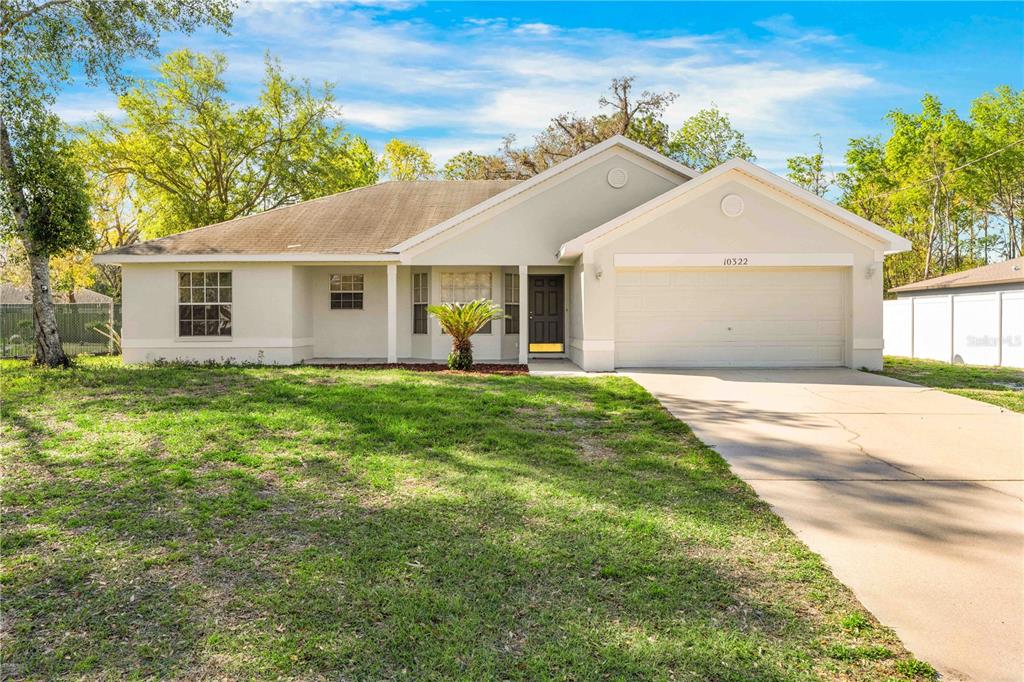 10322 Elnora Street Spring Hill, FL 34608 - Photo 1 of 1 a front view of house with yard and green space
