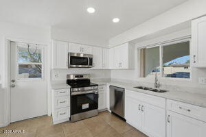 15601 North 22nd Street Phoenix, AZ 85022 - Photo 4 of 27 a kitchen with granite countertop white cabinets and stainless steel appliances