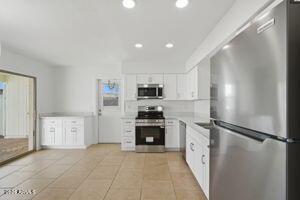 15601 North 22nd Street Phoenix, AZ 85022 - Photo 7 of 27 a kitchen with a refrigerator and a stove top oven
