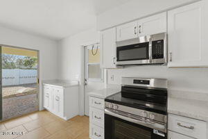 15601 North 22nd Street Phoenix, AZ 85022 - Photo 9 of 27 a kitchen with stainless steel appliances a stove microwave and sink
