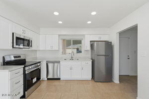 15601 North 22nd Street Phoenix, AZ 85022 - Photo 10 of 27 a kitchen with a refrigerator and a stove top oven