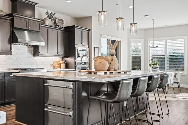 a kitchen with stainless steel appliances granite countertop a sink stove and cabinets