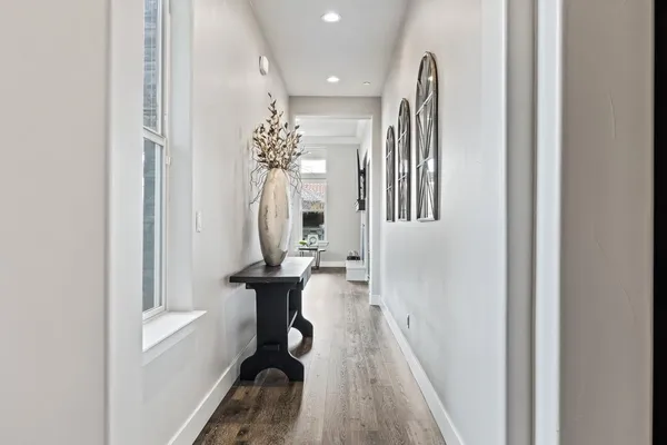 a view of a hallway with furniture and floor to ceiling window