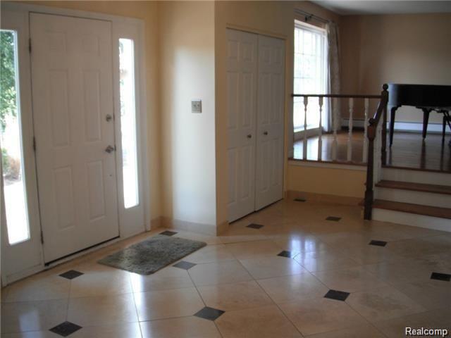 Foyer with travertine marble tile which leads up to the family room.