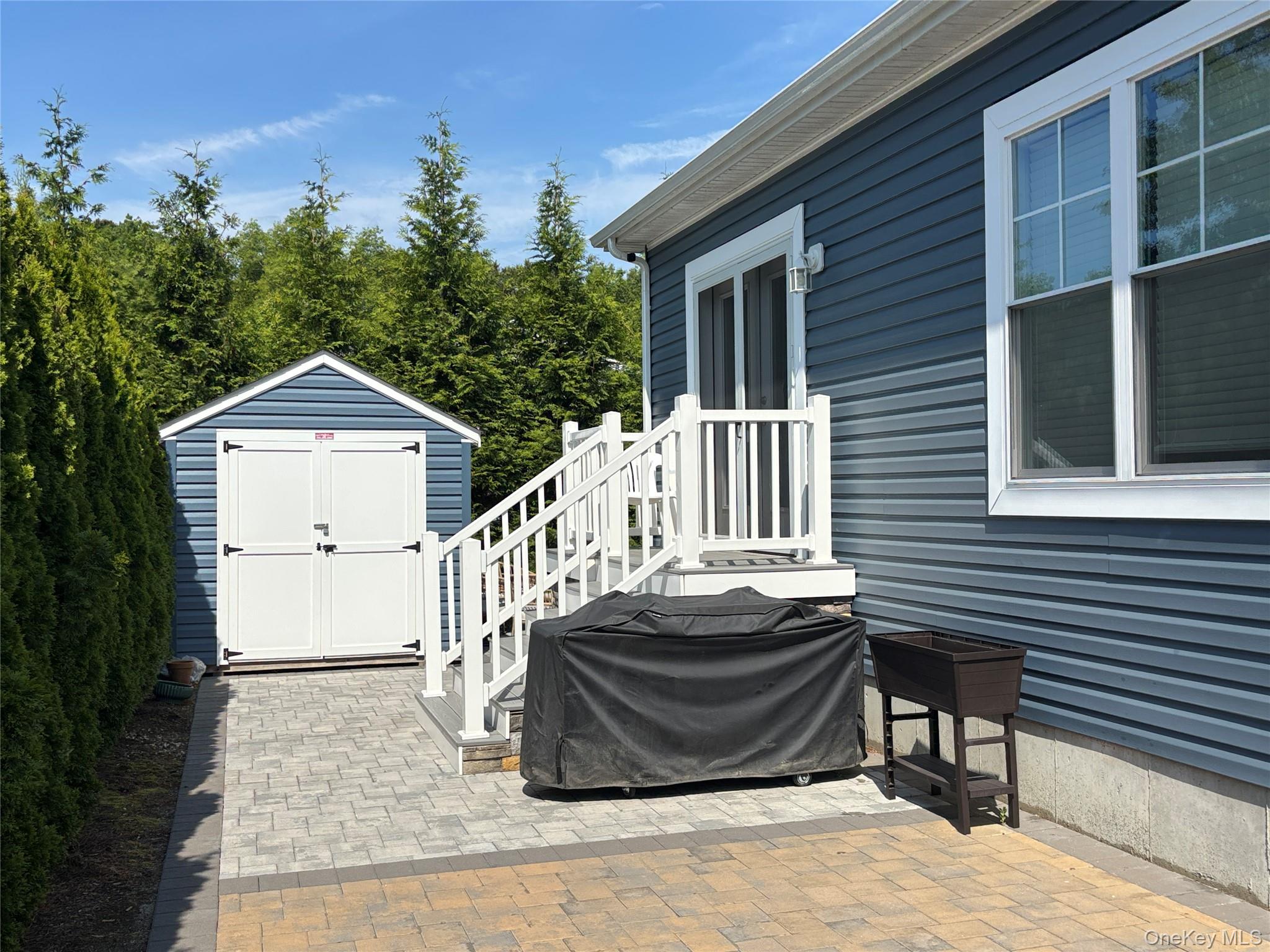 1661 Old Country Road, Unit 563 Riverhead, NY 11901 - Photo 4 of 43 a front view of a house with a garden and pathway