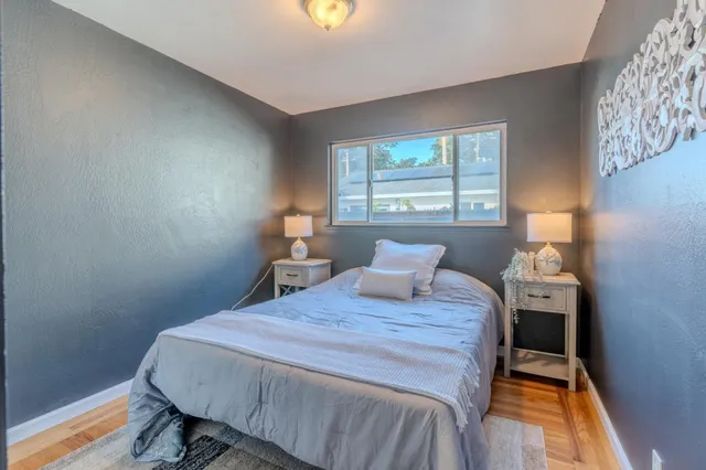 a bedroom with a bed and wooden floor