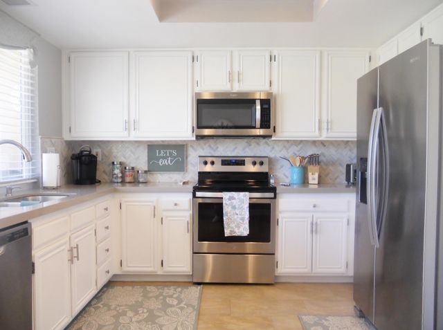 a kitchen with stainless steel appliances granite countertop a refrigerator sink and stove