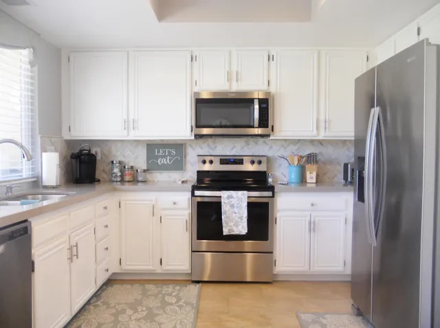 a kitchen with stainless steel appliances granite countertop a refrigerator sink and stove