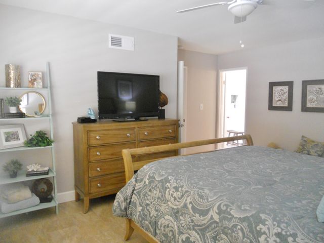 a bedroom with a bed and a flat tv screen on dresser