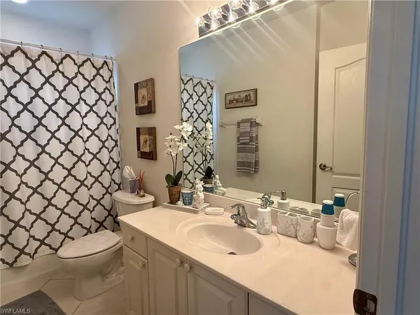 a bathroom with a sink mirror and a toilet