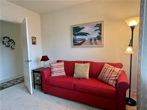 a blue couch sitting in a living room with a lamp