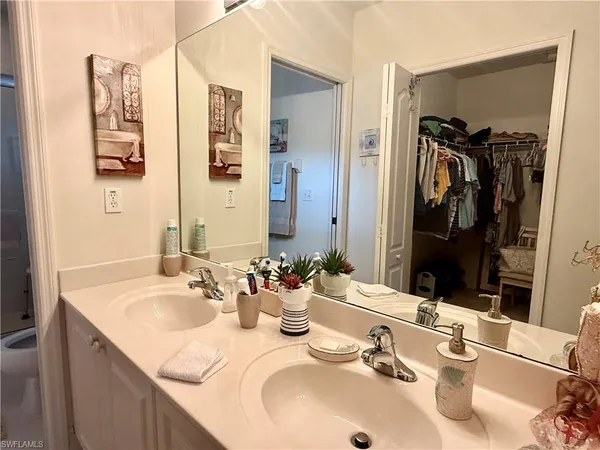 a bathroom with double vanity sinks a mirror and a shower