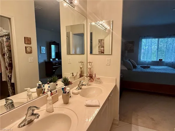 a en suite bathroom with sinks granite countertop tub and a mirror