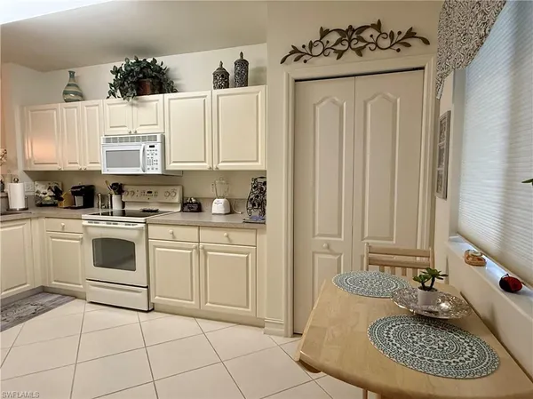 a kitchen with a white cabinets and white appliances