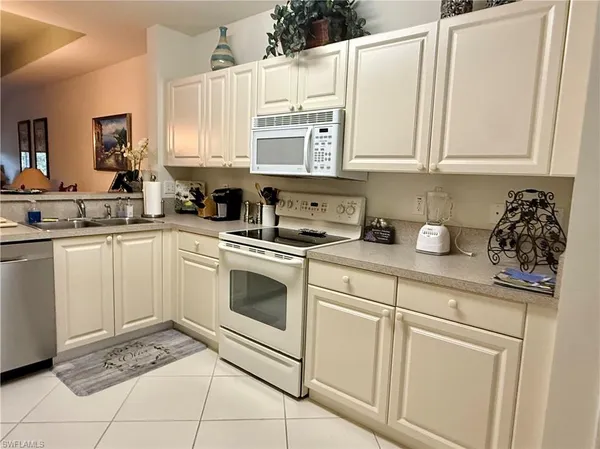 a kitchen with white cabinets and white appliances