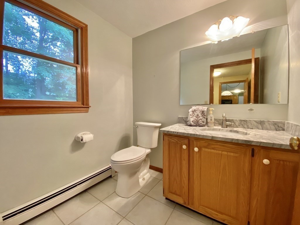 22 Old Homestead Road Groton, MA 01450 - Photo 18 of 36 a bathroom with a granite countertop sink toilet and mirror