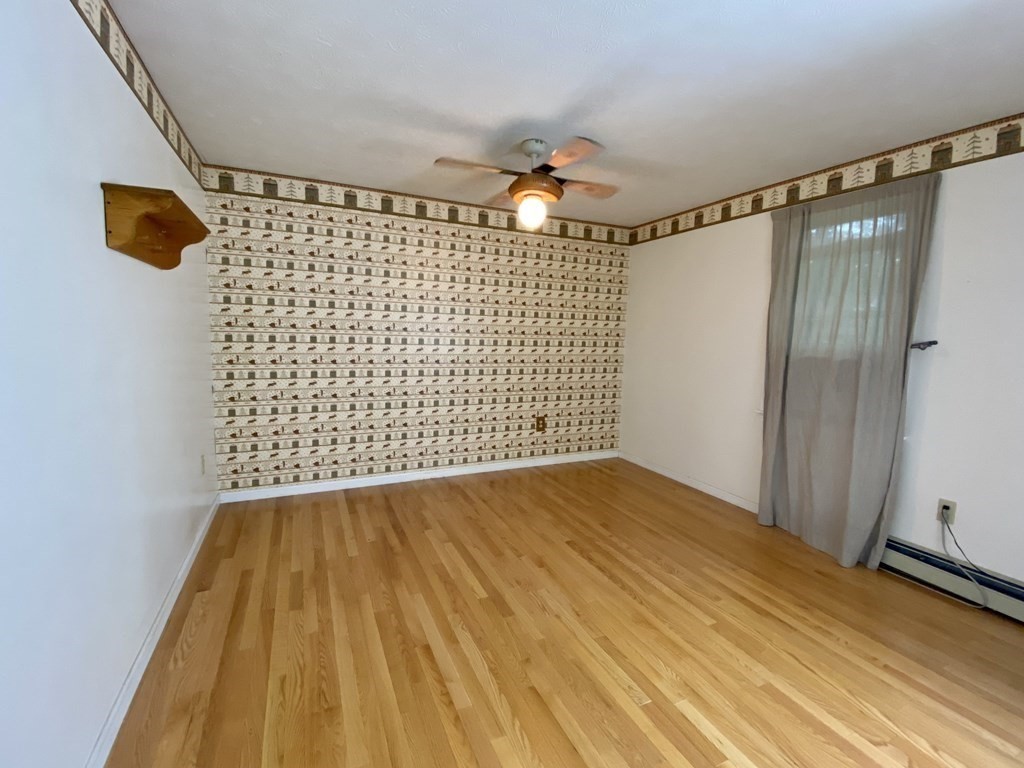 22 Old Homestead Road Groton, MA 01450 - Photo 26 of 36 a view of empty room with wooden floor and fan