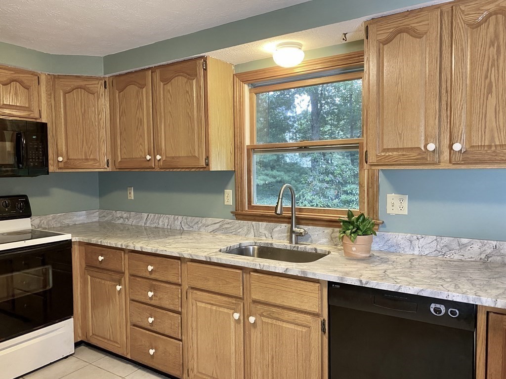 22 Old Homestead Road Groton, MA 01450 - Photo 7 of 36 a kitchen with granite countertop a sink window and cabinets