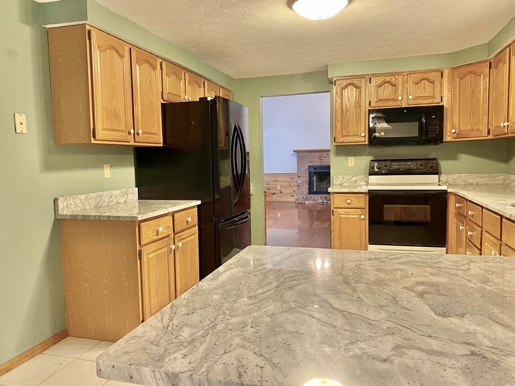 22 Old Homestead Road Groton, MA 01450 - Photo 8 of 36 a kitchen with stainless steel appliances granite countertop a stove refrigerator and microwave