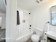 a white toilet sitting next to a bath tub