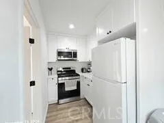 a kitchen with stainless steel appliances white cabinets and a refrigerator