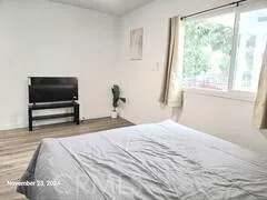 a bedroom with a bed and large window