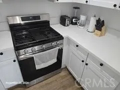 a kitchen with a stove and white cabinets