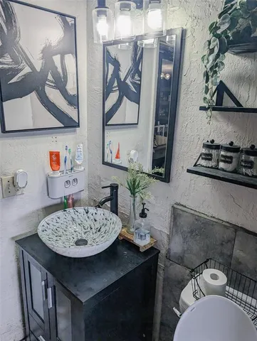 a bathroom with a sink a stove and cabinets