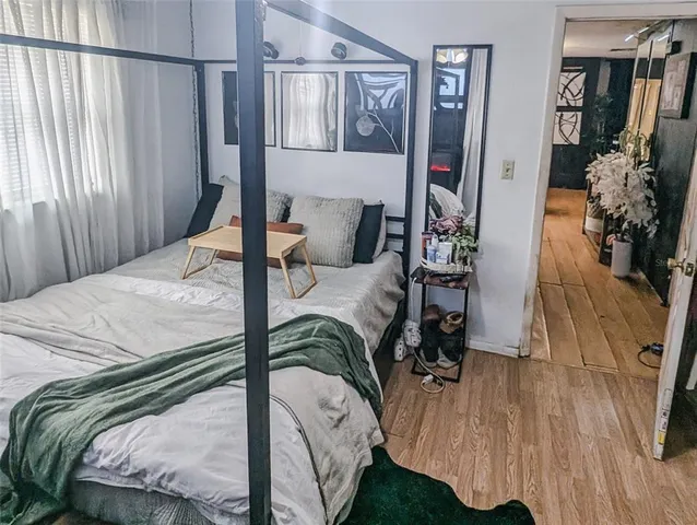 a bedroom with a bed and wooden floor