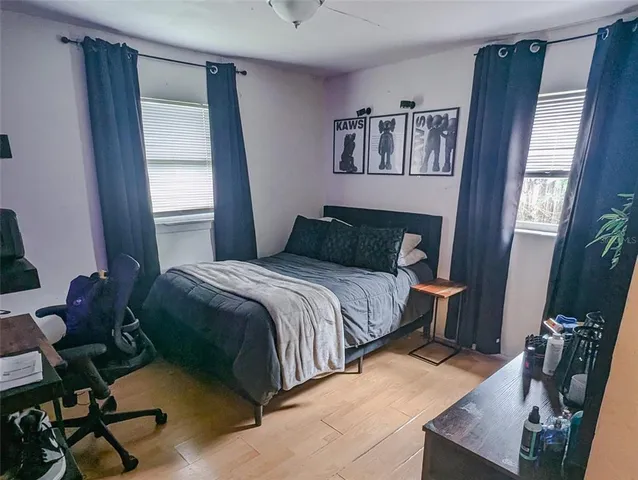 a bedroom with a bed and wooden floor