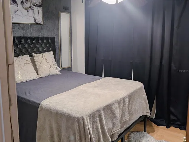 a bed sitting in a bedroom next to a wooden cabinet