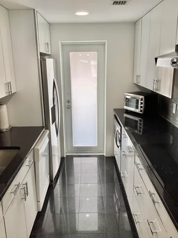 a bedroom with a bed and a flat tv screen on dresser