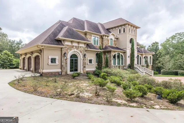 a front view of a house with a yard and potted plants