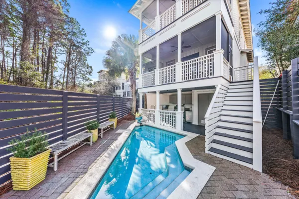 a view of a house with backyard and wooden fence