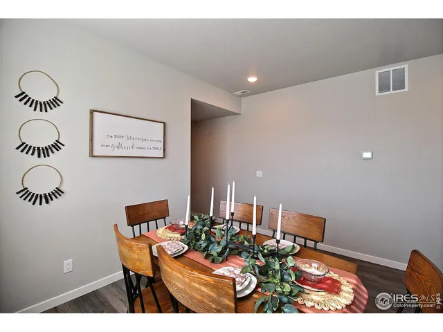 a kitchen with stainless steel appliances granite countertop a dining table chairs and white cabinets