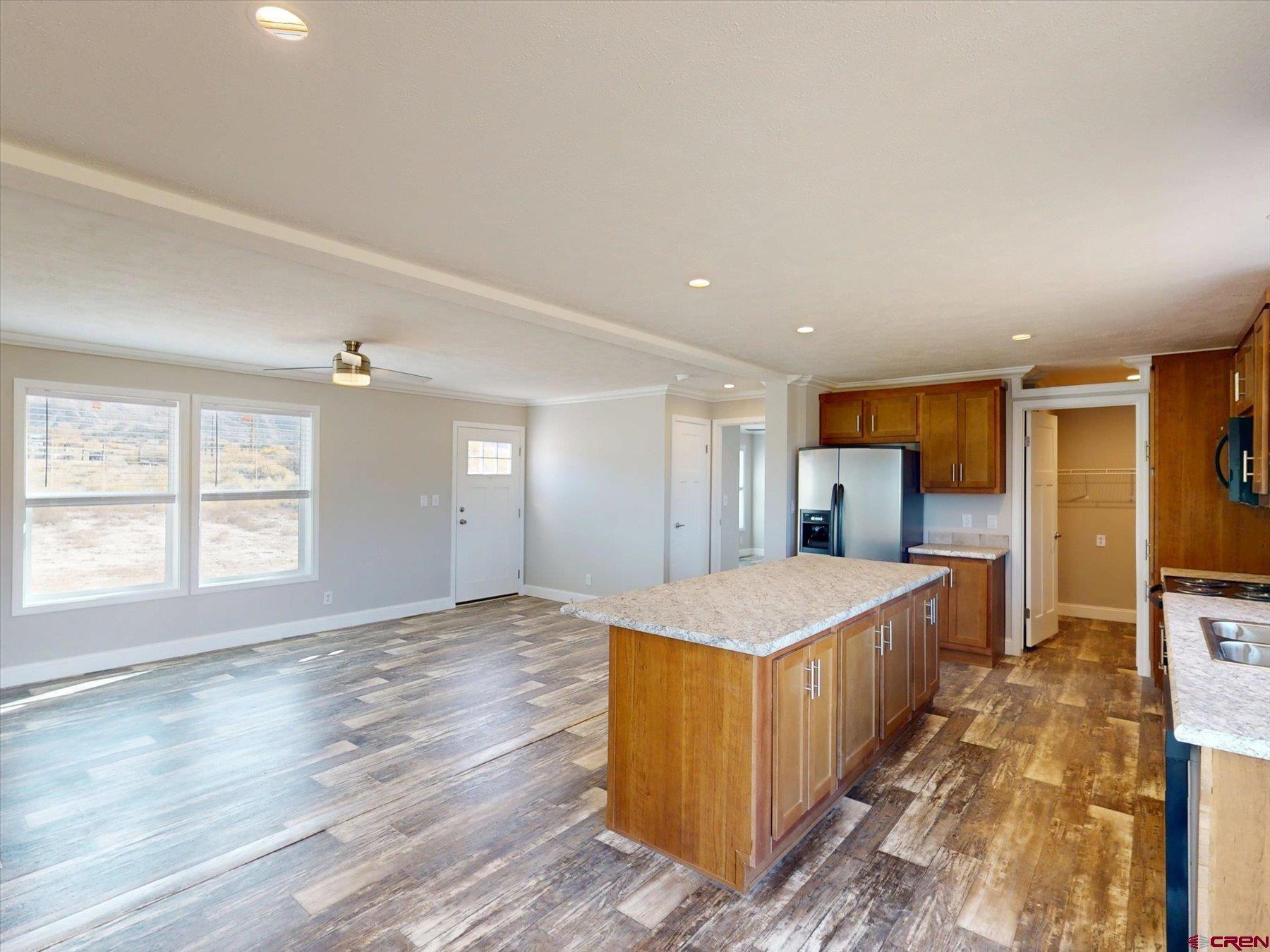 2229 Highway 160 Cortez, CO 81321 - Photo 13 of 32 a large room with kitchen island a sink wooden floor and a window
