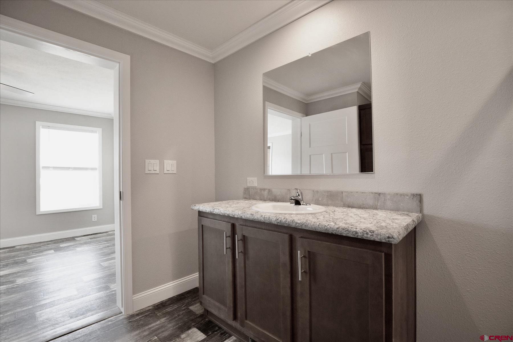 2229 Highway 160 Cortez, CO 81321 - Photo 14 of 32 a en suite bathroom with a granite countertop sink and a mirror