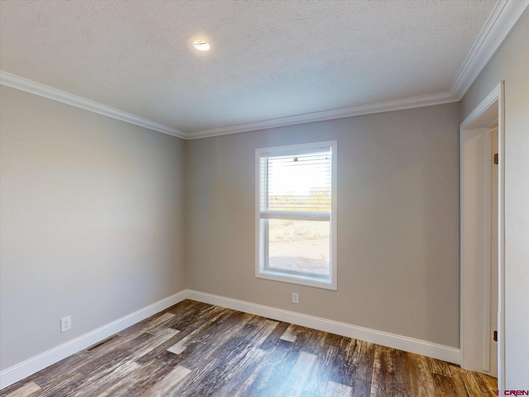 2229 Highway 160 Cortez, CO 81321 - Photo 15 of 32 an empty room with wooden floor and windows