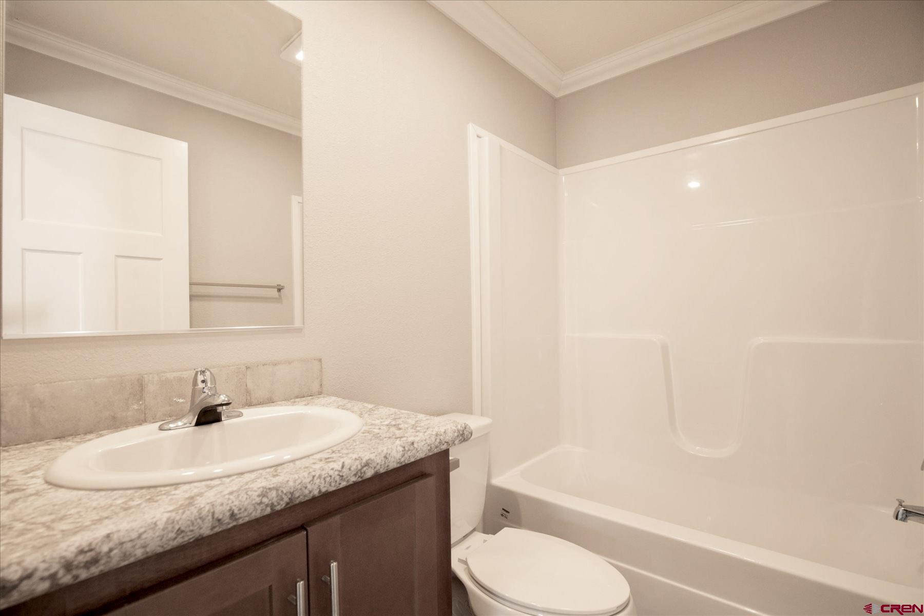 2229 Highway 160 Cortez, CO 81321 - Photo 19 of 32 a bathroom with a granite countertop sink toilet and shower