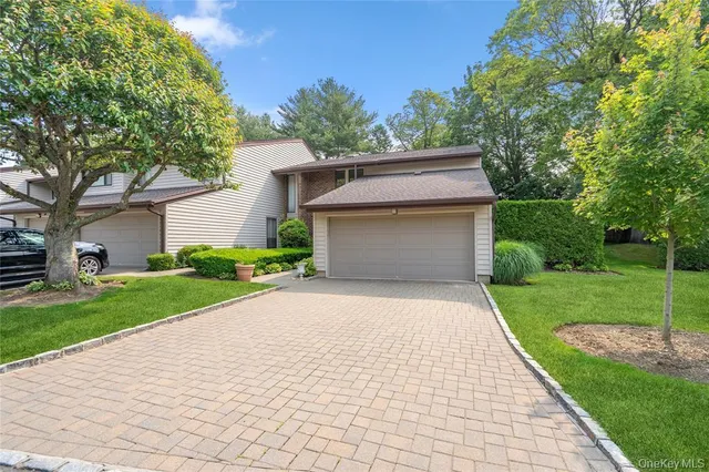 a front view of a house with a yard and trees