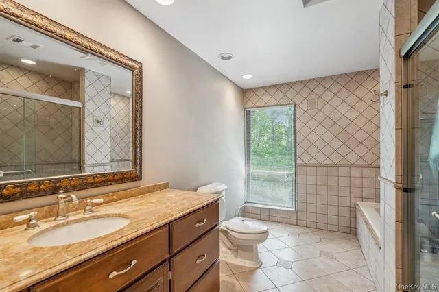 a bathroom with a granite countertop sink a toilet and shower