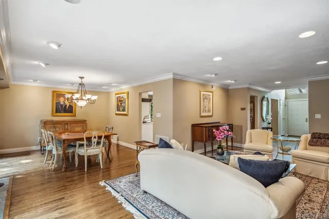 a living room with furniture a dining table and wooden floor