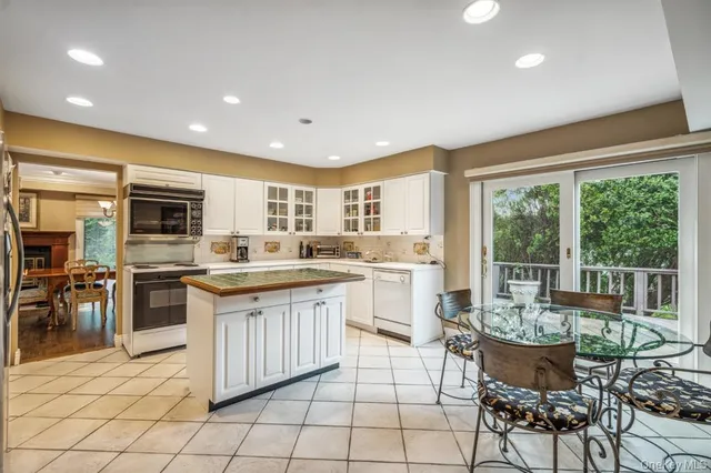 a kitchen with a dining table chairs and white appliances