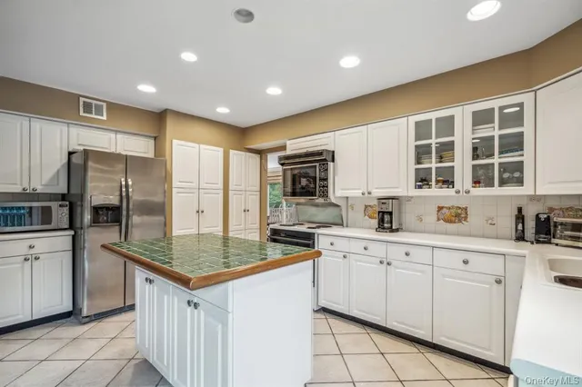 a kitchen with granite countertop a sink stove and refrigerator