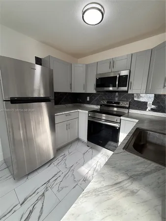 a kitchen with stainless steel appliances granite countertop a refrigerator sink and stove
