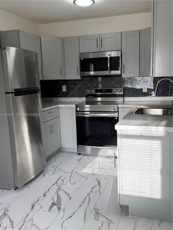 a kitchen with a refrigerator stove and microwave