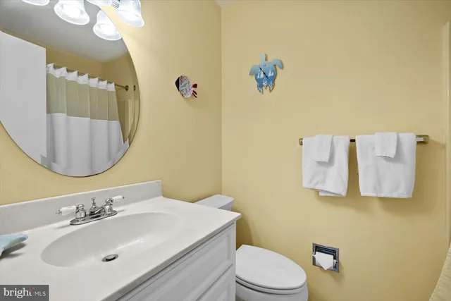 a bathroom with a sink vanity mirror and toilet