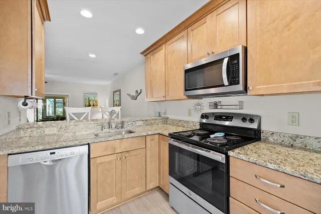 a kitchen with stainless steel appliances granite countertop a sink stove and microwave