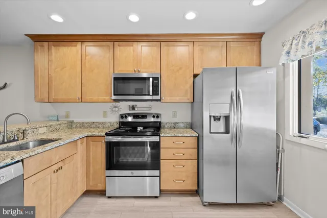 a kitchen with stainless steel appliances granite countertop a refrigerator stove and microwave
